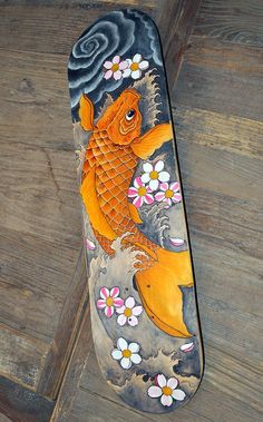 the skateboard is decorated with an image of a fish on it's side