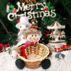 a small stuffed animal sitting in a basket on top of snow covered ground next to a christmas tree