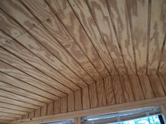 the inside of a room with wood paneling on the ceiling and windows in it