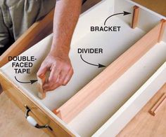 a man is opening the drawer with his hand and pointing it at the tape on the bottom