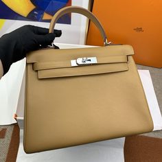 Description HRMS Kelly 28 Evercolor Gold Bag For Women, Handbags, Shoulder Bags 11in/28cm Rep 1:1 Hermès bags are considered the ultimate luxury item worldwide. Each piece is handcrafted with waitlists that can exceed a year or more. The streamlined and demure Kelly style is always in high demand; it is particularly lovely in this vibrant version with silver hardware. Evercolor is textured with a wonderful grainy appearance. Evercolor is soft to the hand and maintains the shape of the bag well o Dior Bucket Hat, Chanel Coco Handle, Hermes Kelly 28, Book Tote Bag, Chanel Tote, Stylish Handbags, Gold Bag, Luxury Products, Hermes Bags