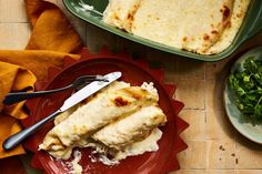 two plates with food on them next to a bowl of salad and a plate of flatbreads