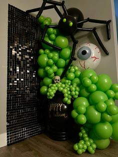 a halloween decoration made out of balloons with a spider on the top and green grapes in the bottom