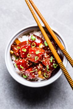 two chopsticks sticking out of a bowl of food