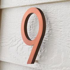 an orange number hanging on the side of a white door with a black ring around it