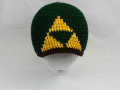 a green and yellow knitted hat on top of a white mannequin head