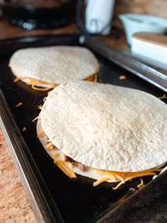 two tortillas sitting on top of a baking sheet