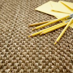 three pencils are laying on the ground next to an envelope and some yellow paper