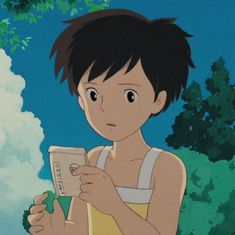 a young boy holding a book in front of trees with clouds and blue sky behind him