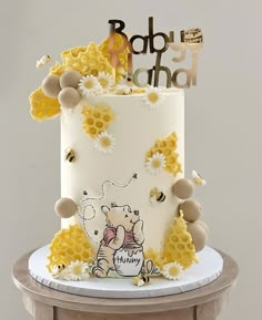 a baby shower cake with honeycombs and bees on the top is decorated in white frosting