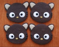 four decorated cookies with eyes and ears on a table