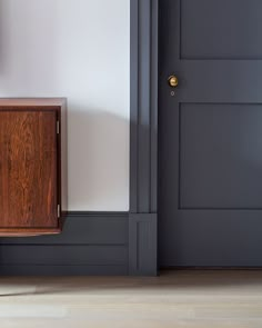 an empty room with a wooden cabinet next to the door