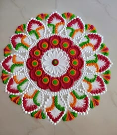 an image of a colorful flower design on the floor with white marbles in the background