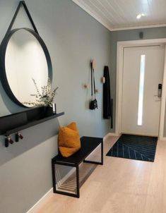 a hallway with a bench, mirror and coat rack