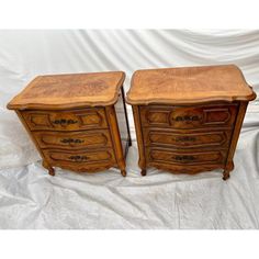 two wooden dressers sitting next to each other on top of a white cloth covered floor