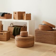 wicker baskets are stacked on top of each other in front of a white wall