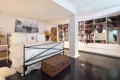 a bedroom with a bed, bookshelf and chest of drawers