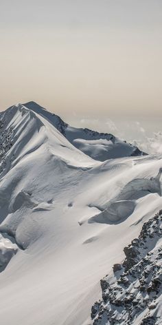 a person on skis standing at the top of a snow covered mountain