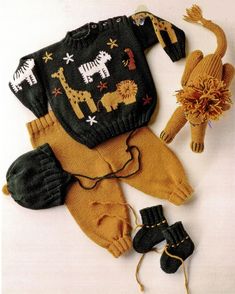 an assortment of knitted clothing and toys on a white surface