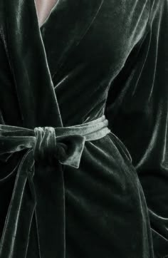 a woman wearing a green robe with a tie around her waist