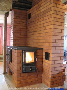 a wood burning stove sitting inside of a brick wall