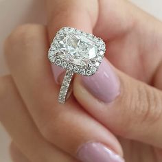 a close up of a person holding a ring with a diamond on the middle of it