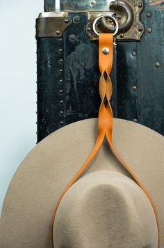 a hat is hanging on a hook in front of a door with an orange ribbon around it