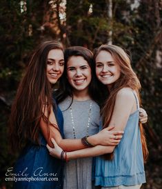 three girls hugging each other and smiling for the camera with their arms around one another