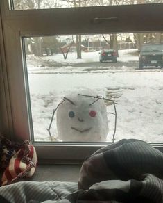 a snowman is looking out the window