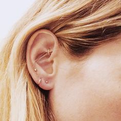 a woman's ear with two piercings on it