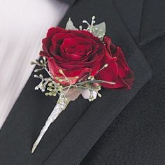 a boutonniere with a single red rose on it's lapel