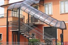 a house with a metal staircase going up to the second floor and an awning over it