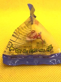 a plastic triangle shaped object sitting on top of a yellow cloth covered table with chinese writing