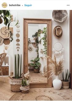 a mirror sitting on top of a wooden table next to plants and potted plants