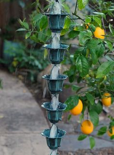 an outdoor fountain with oranges hanging from it