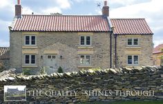 an old stone house with a red tiled roof