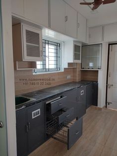 an empty kitchen with wooden floors and white cabinets