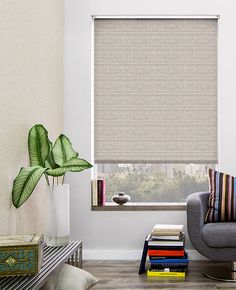 a living room with a couch, chair and large window covered in roman blind shades