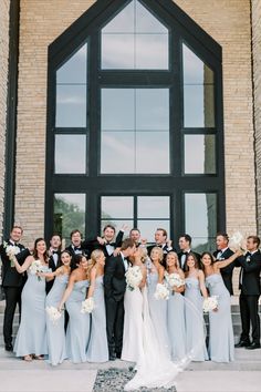 a group of people that are standing in front of a building and posing for a photo