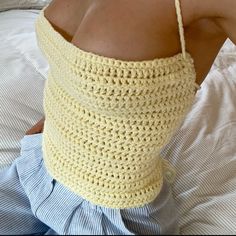 a woman laying in bed wearing a crocheted neck garter with her hands on her hips