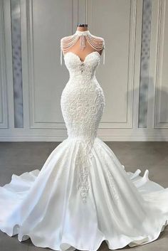 a white wedding dress on display in a room