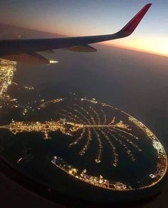 an airplane wing flying over a city at night