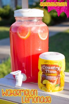 a jar of watermelon lemonade sitting on top of a table next to a can of lemonade