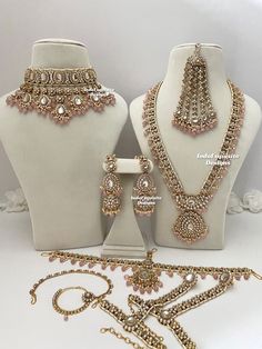 two white mannequins with pink and gold jewelry on display next to each other