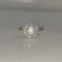 a white diamond ring sitting on top of a table