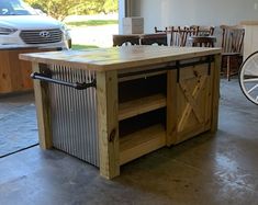 a kitchen island made out of metal and wood with wheels on the floor next to it