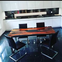 a dining room table with black chairs and a wooden slab top in the middle of it