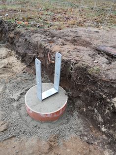 there is a cement base with two metal poles sticking out of the ground next to it