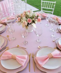 the table is set with pink napkins and place settings