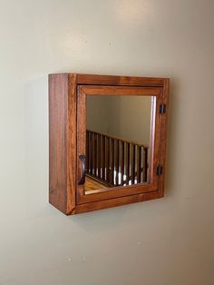 a mirror mounted to the side of a wall next to a wooden crib in a room